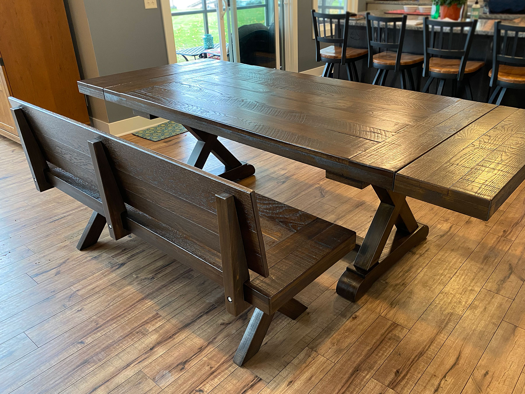 The fulton trestle farmhouse table in Heirloom Oak on White Oak, Rough Rustic. Leaf extensions.