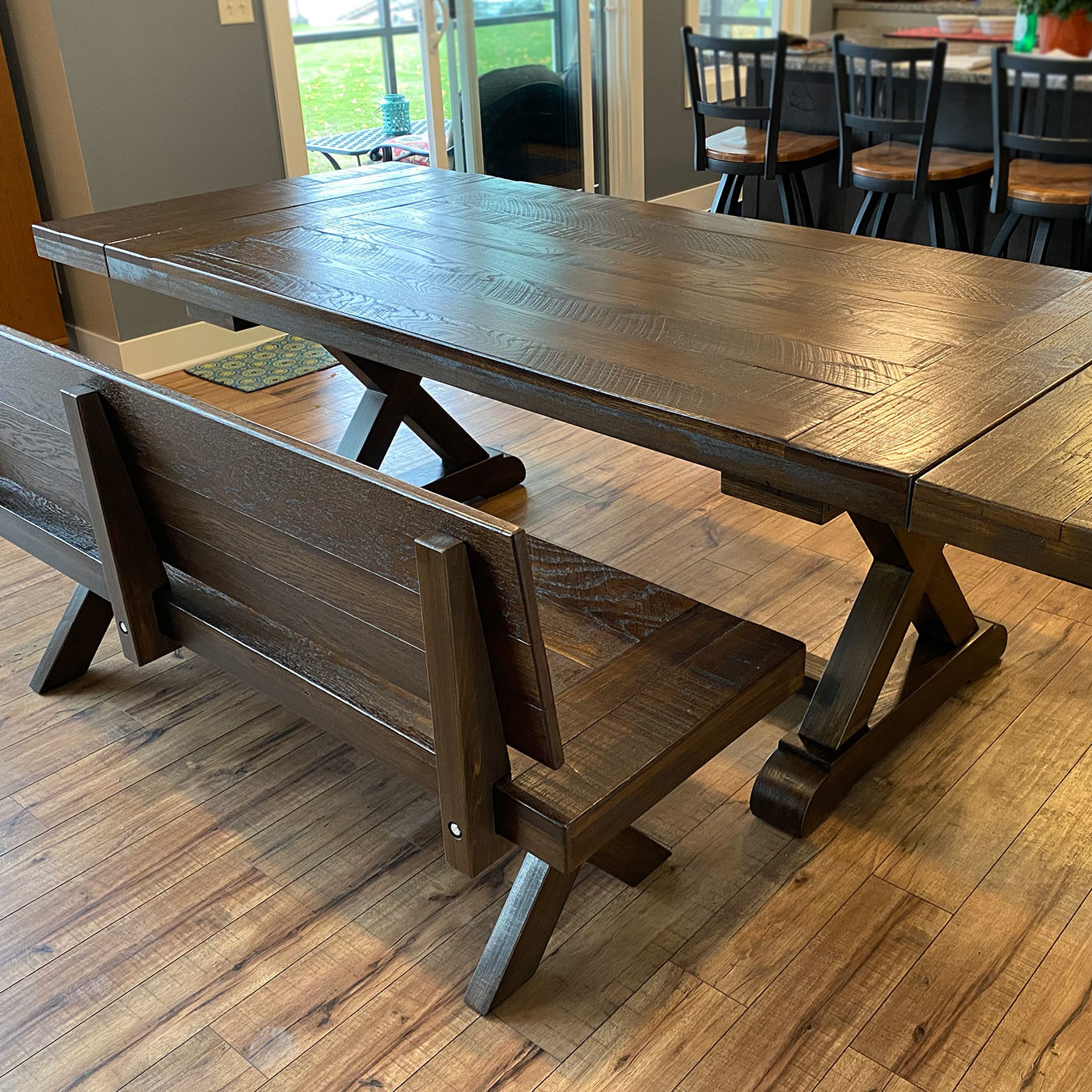 The fulton trestle farmhouse table in Heirloom Oak on White Oak, Rough Rustic. Leaf extensions.